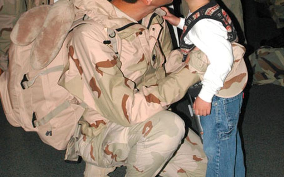 Lt. Col. Douglas Dickerson, 374th Logistics Readiness Squadron director of operations, gets a kiss from his son, Alex, upon returning home from a four-month deployment to southwest Asia.