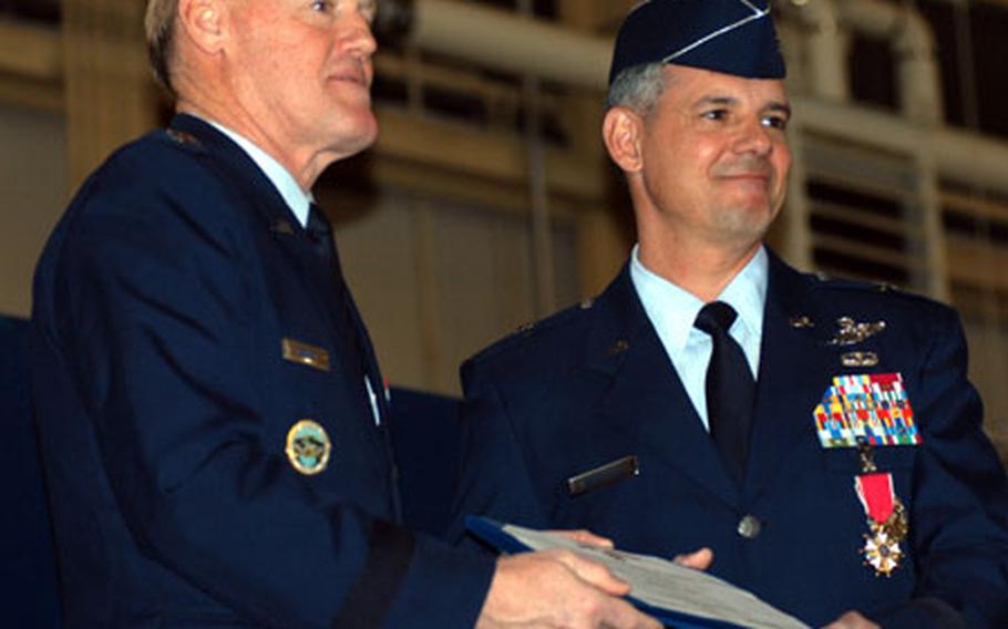Brig. Gen. Sam Angelella, left, accepts a Legion of Merit Award from Lt. Gen. Bruce Wright, U.S. Forces Japan and 5th Air Force commander. Wright spoke at the 35th Fighter Wing change-of-command ceremony Wednesday at Misawa Air Base, Japan.