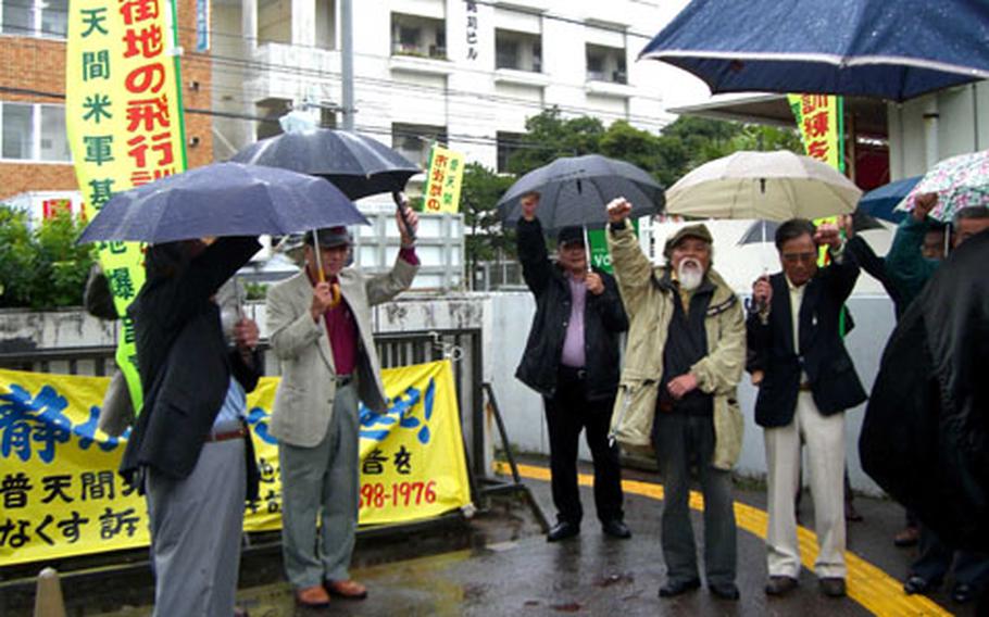 About 20 residents and their supporters rally before a court session Thursday at the Okinawa City Branch of the Naha District Court. About 400 Ginowan residents are suing the national government, seeking $2.56 million in damages. They claim to suffer from aircraft noise from Marine Corps Air Station Futenma.