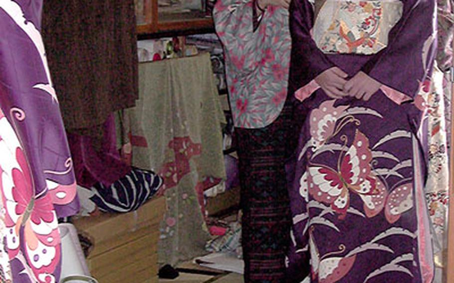 Kate Jaffer,right, checks to see how her kimono looks as a fitter makes final adujstments just before the Sasebo Coming of Age Ceremony Jan. 8. Jaffer, daughter of a Navy lieutenant commander now stationed in Okinawa, attended a Japanese junior high school in Sasebo for two yearsand was invited back to atend the ceremony.