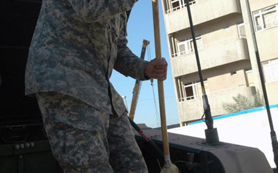 Spc. Eric Rose, 21, of Tracy, Calif., a member of Company D of the 82nd Airborne Division&#39;s 1st Battalion, 504th Parachute Infantry Regiment, sweeps off the bed of his Humvee at Forward Operating Base Loyalty in Baghdad, Iraq.