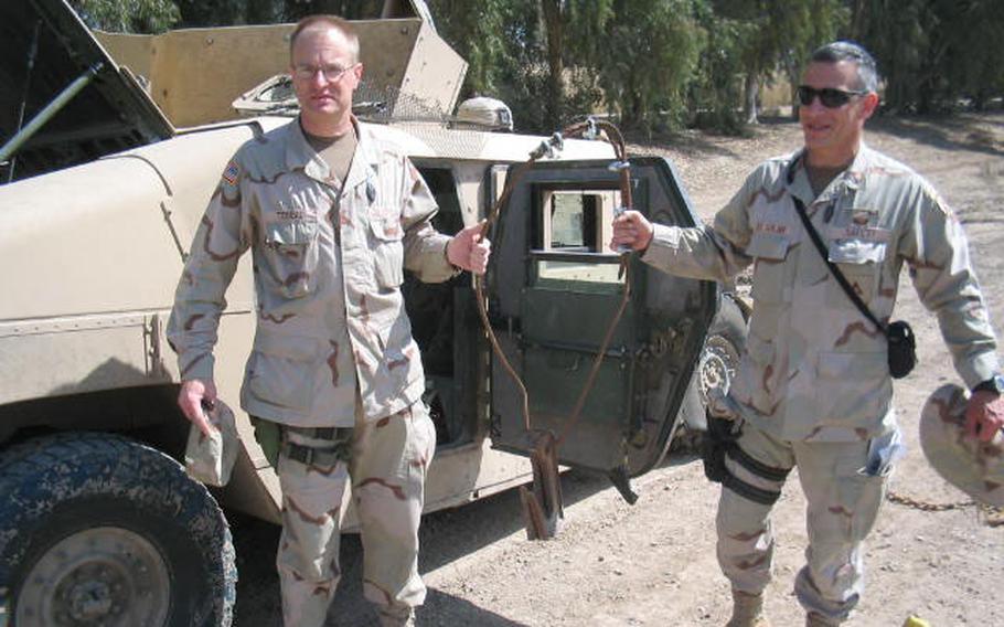 At right, Bill del Solar, safety officer with the 2nd Brigade Combat Team, 10th Mountain Division, invented what he called the "Door Puller" to get trapped servicemembers out of damaged vehicles. He and Karl Tabeau, Army Materiel Command, who helped with the testing, hold up their first version.