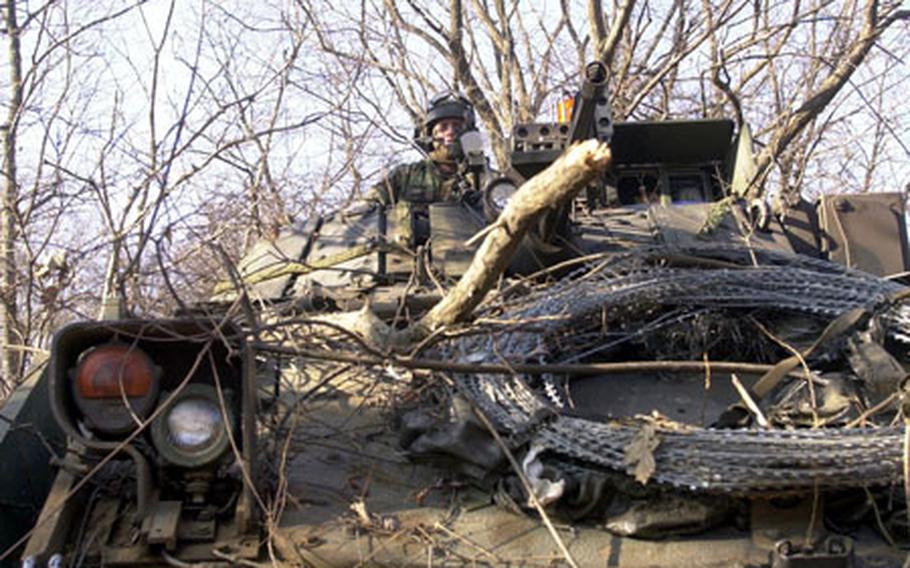 Staff. Sgt. Frank Howard awaits simulated battle with opposing forces while concealed under a tree line in his Bradley Fighting Vehicle at a training area near Yeoncheon on Friday.