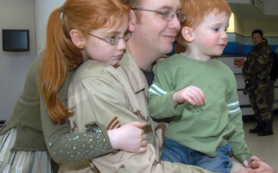 Tech. Sgt. Gregory James, a power production specialist with the 423rd Civil Engineering Squadron at RAF Alconbury, England, spends a few moments with his 8-year-old daughter, Bailey, and 3-year-old son, Carson, before deploying to Qatar on Tuesday. About 350 airmen deployed from RAF Mildenhall's passenger terminal as part of the Air Expeditionary Force 5/6 rotations.
