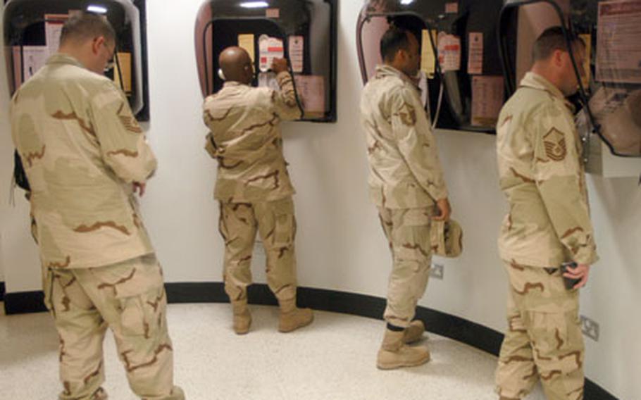 Airmen awaiting to deploy to Qatar as part of the Air Expeditionary Force 5/6 rotations make phone calls to loved ones at RAF Mildenhall&#39;s passenger terminal on Tuesday.