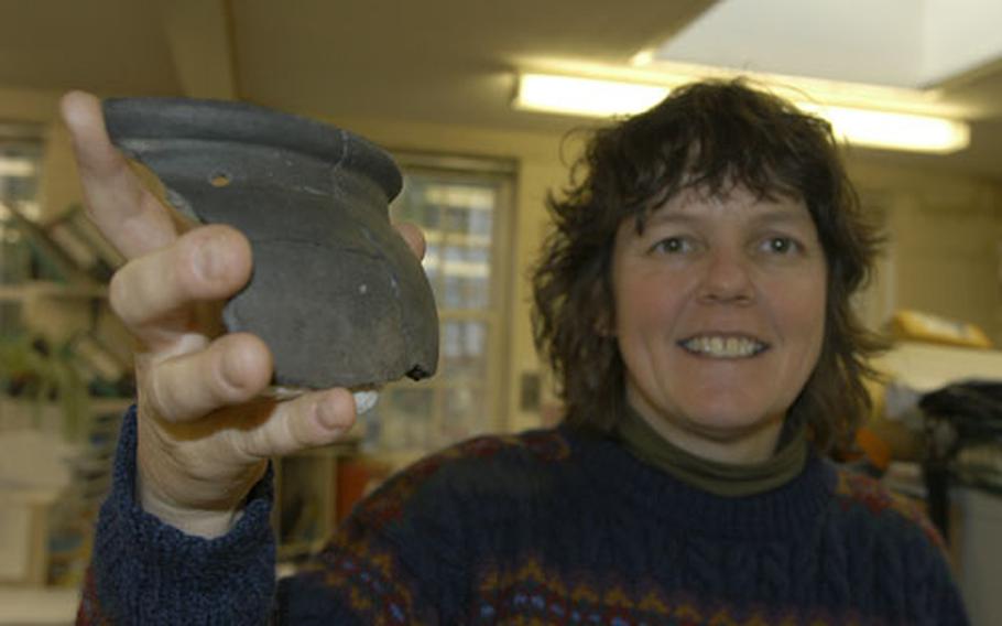 Suffolk County Council archaeologist Jo Caruth holds a piece of 1st Century cooking pottery that predates the Roman period of British history. The pottery was excavated from a site on Beck Row where a developer is building American style homes.