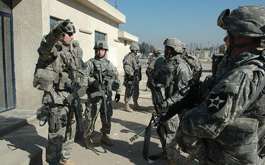 Staff Sgt. Kevin Palmer (pointing), Police Transition Team chief and part of the 240th Military Police Company, briefs 82nd Airborne Division officials about a joint security station in East Baghdad.