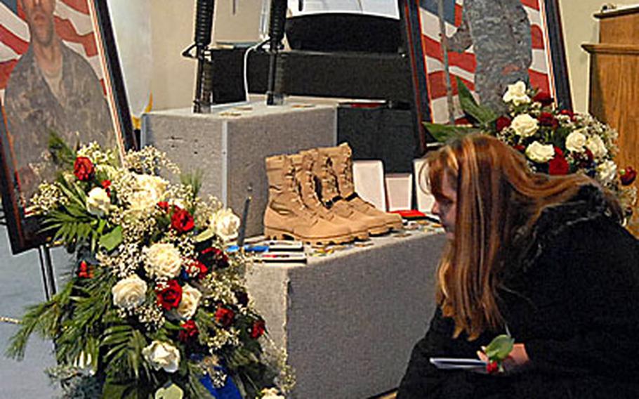 A mourner puts a flower in front of a photo of Sgt. Edward Shaffer following the memorial ceremony for Shaffer and Pfc. David Dietrich in Friedberg, Germany, on Wednesday.