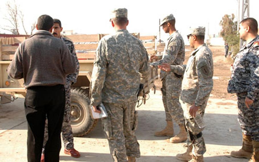 Members of the U.S. military’s National Police Transition Team for the 8th Brigade, 2nd National Police, unload two new computers they bought in January for the police brigade headquarters.