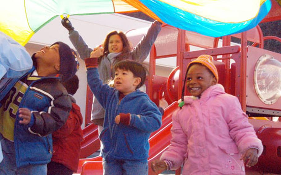 Program assistant Gloria Avelino, center, holds the "big top" for the three- to five -year olds at Yokosuka&#39;s Child Development Center. The CDC could use more employees: The four buildings have 75 slots that can&#39;t be filled due to lack of staffing and 230 children on the non-priority waiting list.