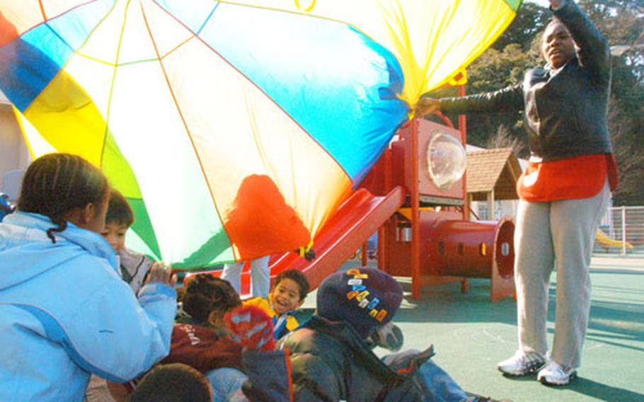 Program assistant Myrielle Boucicault, far right, holds the "big top" for the three- to five -year olds at Yokosuka&#39;s Child Development Center. The CDC could use more employees as the four buildings has 75 slots that can&#39;t be filled due to lack of staffing and 230 children on the non-priority waiting list.