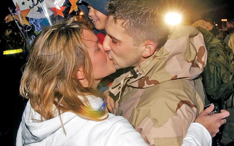 Staff Sgt. Paul Hickey, 48th Equipment Maintenance Squadron, kisses his wife, Agnes, while holding his 5-year-old son, Peerless. Paul Hickey, along with roughly 300 other airmen, returned to RAF Lakenheath in the early morning hours of Friday after a deployment to the Middle East.