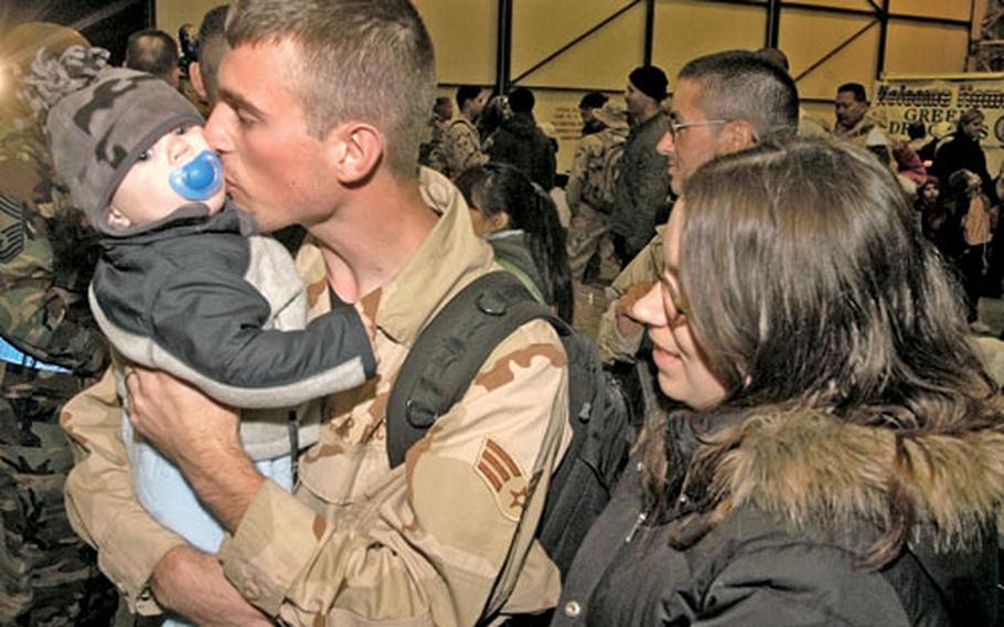 Senior Airman Benny Rutledge, an F-15E jet fighter crew chief from 48th Aircraft Maintenance Squadron, kisses his 10-month-old son, Christopher, as his wife, Senior Airman Charlene Rutledge, from 48th Dental Squadron, watches. Benny Rutledge returned to RAF Lakenheath following a four-month deployment to the Middle East.