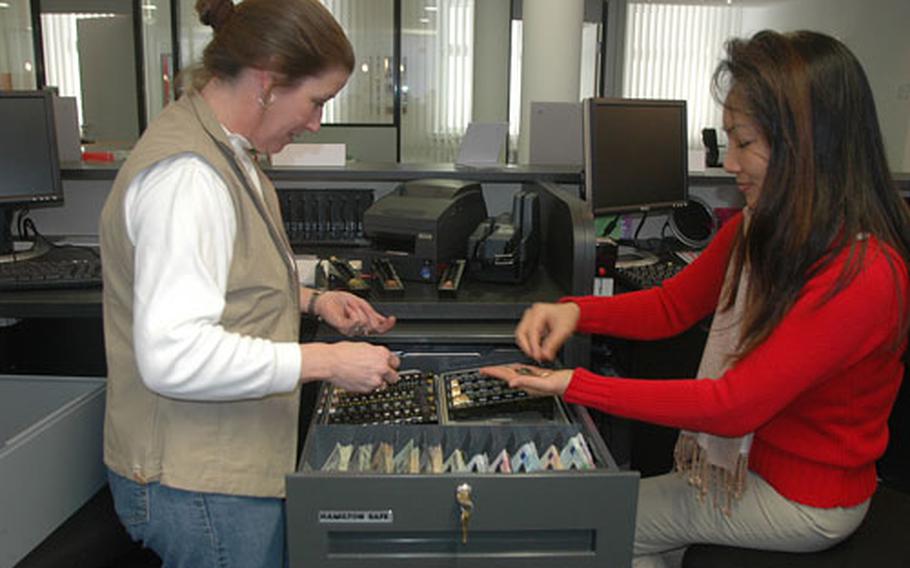 Penny Lonergan, left, and Sunawin Engel prepare a cash drawer at the new Community Bank on Friday in advance of Monday&#39;s opening of the new Community Services building at Panzer Casern near Stuttgart, Germany.