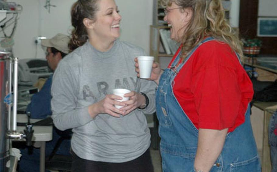 Pfc. Christiaan Christianson, a medic with the 2nd Infantry Division’s Headquarters and Headquarters Company, 2nd Brigade Special Troops Battalion, chats Monday with Michele Sharpley, Morale, Welfare and Recreation technician.