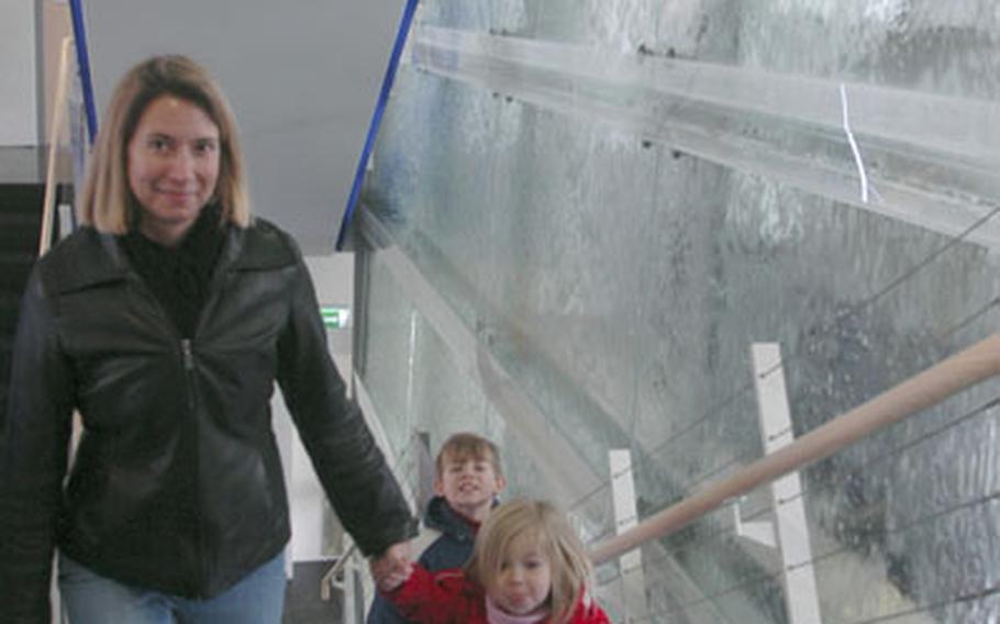 Jan McCoy and her children, Abby, 3, and Benjamin, 8, climb the stairs next to the waterfall inside the new Community Services building at Panzer Casern near Stuttgart, Germany.