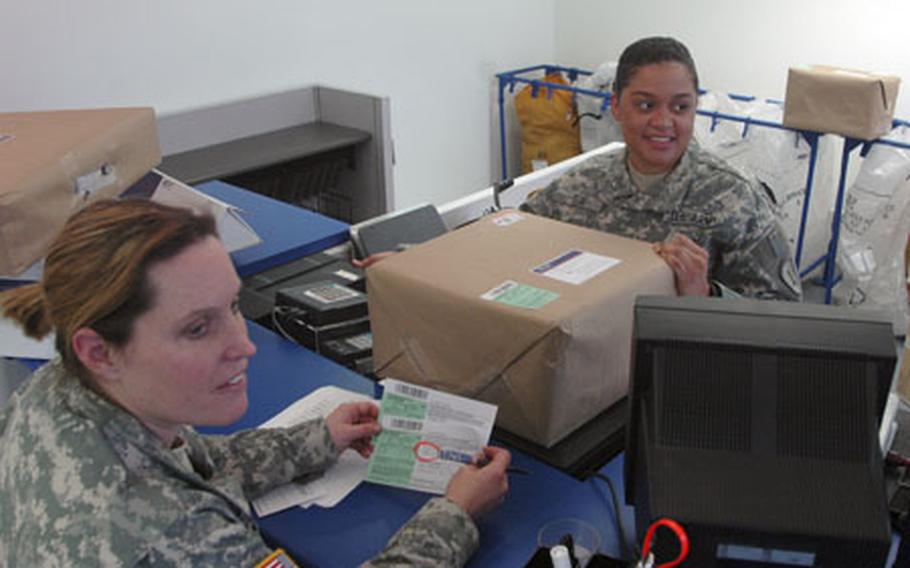 1st Lt. Colleen Born, left, of Company A, 1st Battalion, 174th Air Defense Artillery Regiment, mails home packages Monday with help from Private 1st Class Kenia Felix of 3rd Platoon, 566th Postal Company. Monday was opening day for the Community Services building at Panzer Casern in Boeblingen, Germany, near Stuttgart.