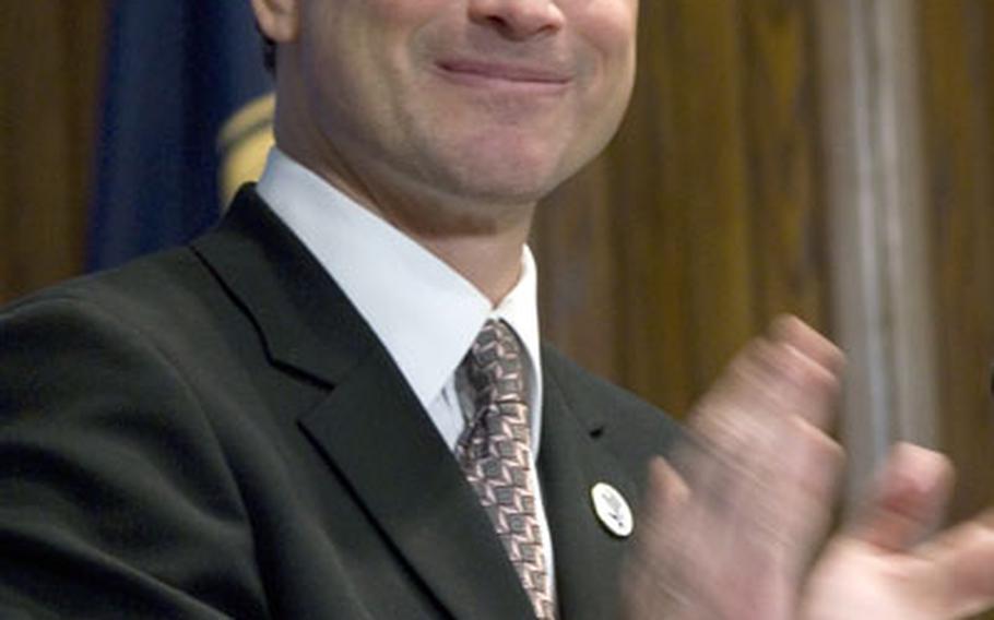 During a speech at the national Press Club, actor Gary Sinise leads a round of applause for servicemembers in the audience.