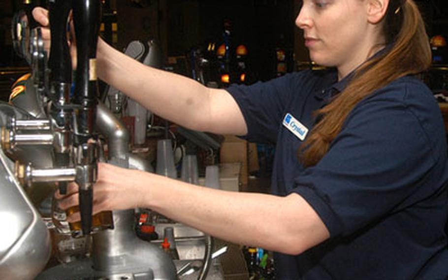 Bartender Crystal Adams pours a pint of beer inside RAF Mildenhall&#39;s Galaxy Club, which will hold a party for this year&#39;s Super Bowl.