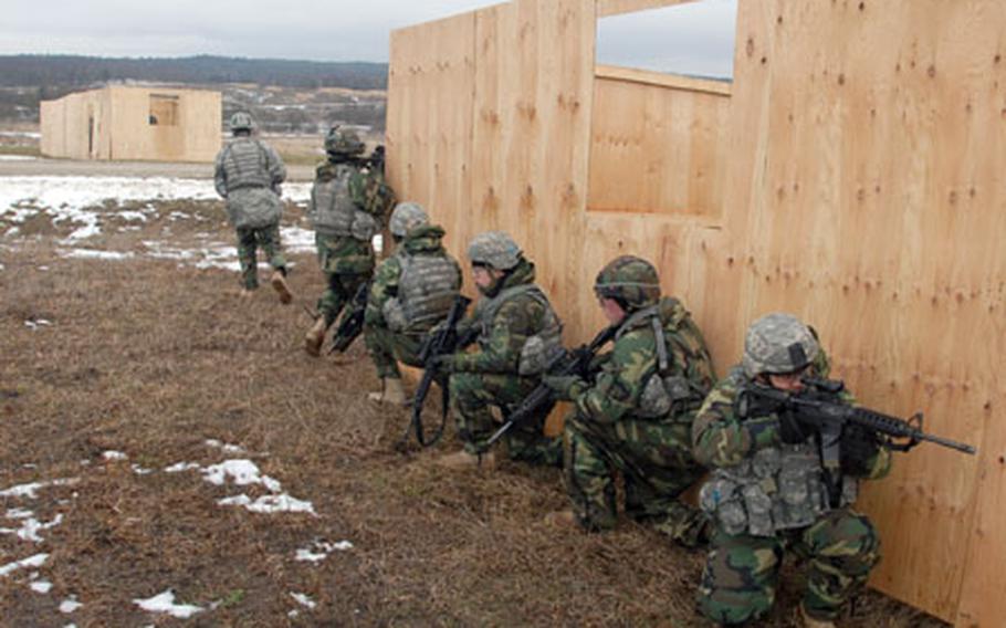 Soldiers storm a MOUT -- military operations in urban terrain -- site at a Grafenwohr training range on Tuesday.