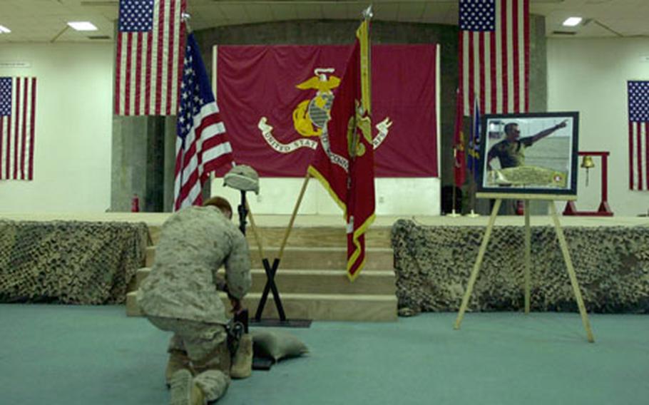 A 3rd Reconnaissance Battalion Marine kneels and pays his final repects during a memorial service for Sgt. Gary S. Johnston on Friday at Camp Fallujah, Iraq.