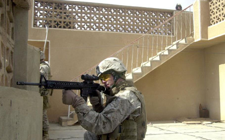 Lance Cpl. Benjamin Ford and fellow Marines with Company E, 2nd Battalion, 3rd Marine Regiment, scan Haditha from a rooftop Wednesday afternoon moments after an insurgent shot at the men. The Marines and Iraqi Police were participating in the two-day Operation Backbreaker II, in which the forces detained 19 suspects.