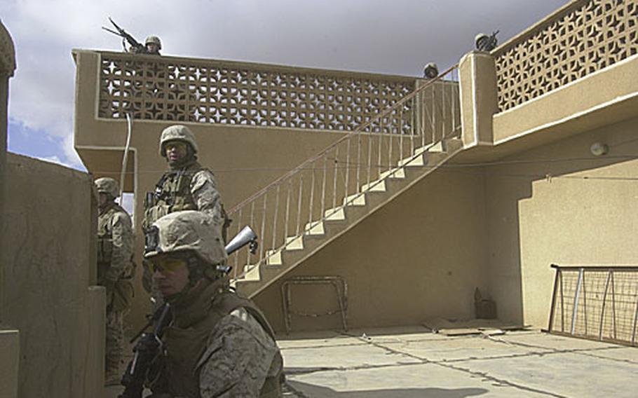 Members of the 3rd Marine Regiment's 2nd Squad, 2nd Platoon, Company E, 2nd Battalion, stand ready to return fire last week after an insurgent took a few pot shots at their location in Haditha. The squad's Marines have a colorful array of nicknames for one another.