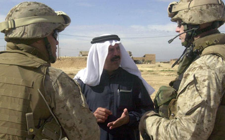 The sheik of Zariyah (center) speaks with Marine Lt. Col. Jim Donnellan, right, commander of the 2nd Battalion, 3rd Marine Regiment, on Friday during an operation in the Iraqi town north of Haditha. The men spoke for two hours while Marines searched homes and asked the town's men for information about themselves for a registry. At least three suspected insurgents were detained.