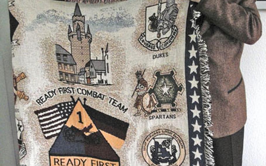 Michael Keller, Friedberg’s mayor, holds a blanket given to him by Michael Tucker, who commanded the 1st Brigade Combat Team, 1st Armored Division, during its first tour in Iraq.