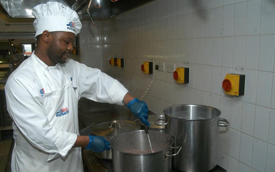 Contractor Peter Sanganza, a cook from Zimbabwe, prepares hamburger Yakisoba during a visit from evaluators to the Hardstand Cafe on RAF Mildenhall on Feb. 6. Culinary specialists at the cafe are vying for top Air Force food service operation honors.