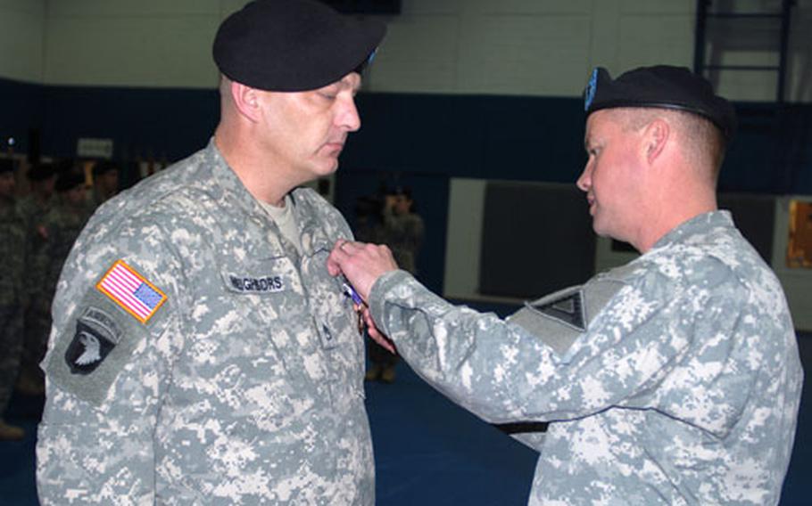 Brig. Gen. David G. Perkins, head of the Joint Multinational Training Command, presents Staff Sgt. Clifford Neighbors with a Purple Heart, Army Commendation Medal (with "V" device) and a Bronze Star Medal during a ceremony Thursday in Hohenfels, Germany, to welcome home members of National Police training teams from a year long mission to Iraq . Neighbors also received the Combat Infantryman Badge and Iraq Campaign Medal.