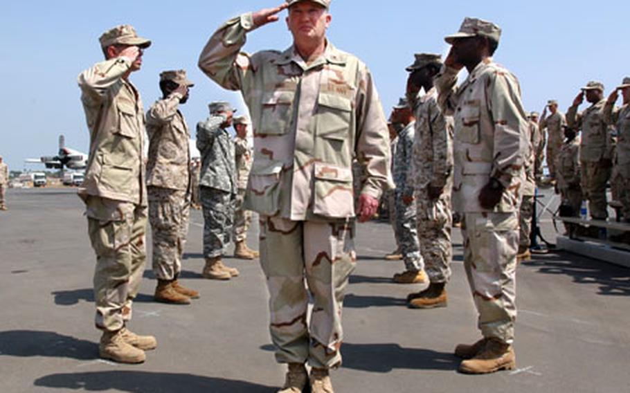Rear Adm. James Hart, the new commander of Combined Joint Task Force - Horn of Africa, passes through a row of saluting servicemembers during a change of command ceremony on Feb. 14 at Camp Lemonier, Djibouti.