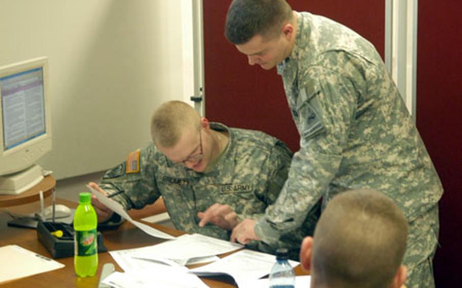 Capt. Brad Crockett, right, helps Pvt. Terry Brumett with a customer's tax filing this week at the tax center in Baumholder, Germany. Since Jan. 29, the tax center has helped file refunds worth $1.4 million.