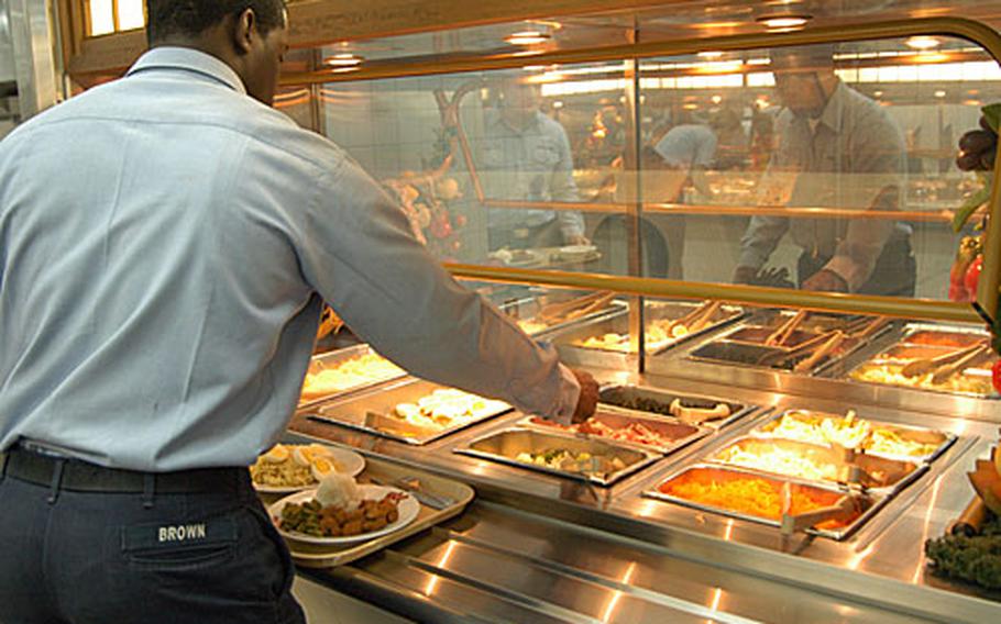 Airman Darra Brown, an aviation boatswain’s mate on USS Kitty Hawk, adds sliced ham to his salad. Expanded salad-bar selection is just one way the Navy Standard Core Menu aims to benefit the Navy, officials said.