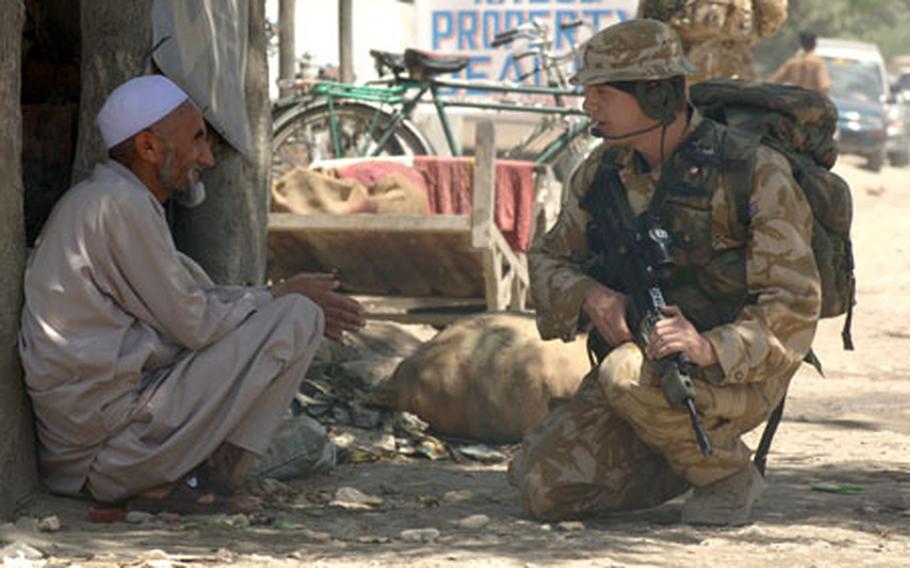 A members of the British army force protection company speaks with a Kabul man during a routine patrol of one of the districts in the city in this June file photo. The patrols were designed to give security and reassurance to the local people.