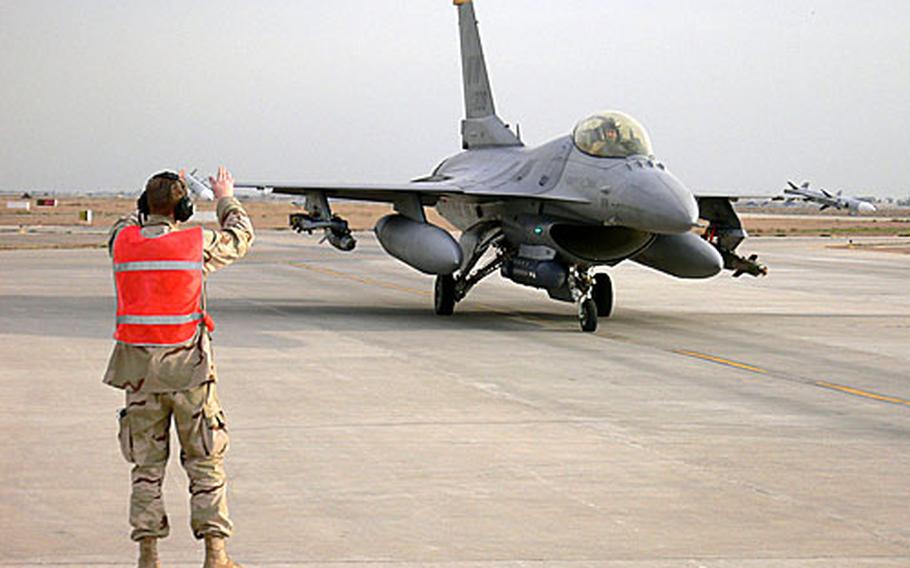 A Misawa airman marshals in an F-16 with the 14th Expeditionary Fighter Squadron at Balad Air Base, Iraq, after its return from a mission in Iraq. The 14th Fighter Squadron was the third expeditionary fighter squadron to stand up at Balad when the Misawa squadron deployed there in January.
