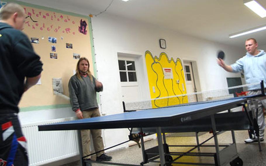 German social worker Stephan Muller (center) watches as two ethnic Russian Germans play table tennis at his drop-in center in Grafenwohr on Thursday night.