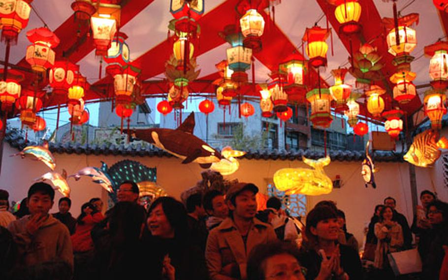People celebrate as the lanterns are lit Sunday evening for the first time during Nagasaki's two-week celebration of Lunar New Year. The festival runs each evening through March 4.