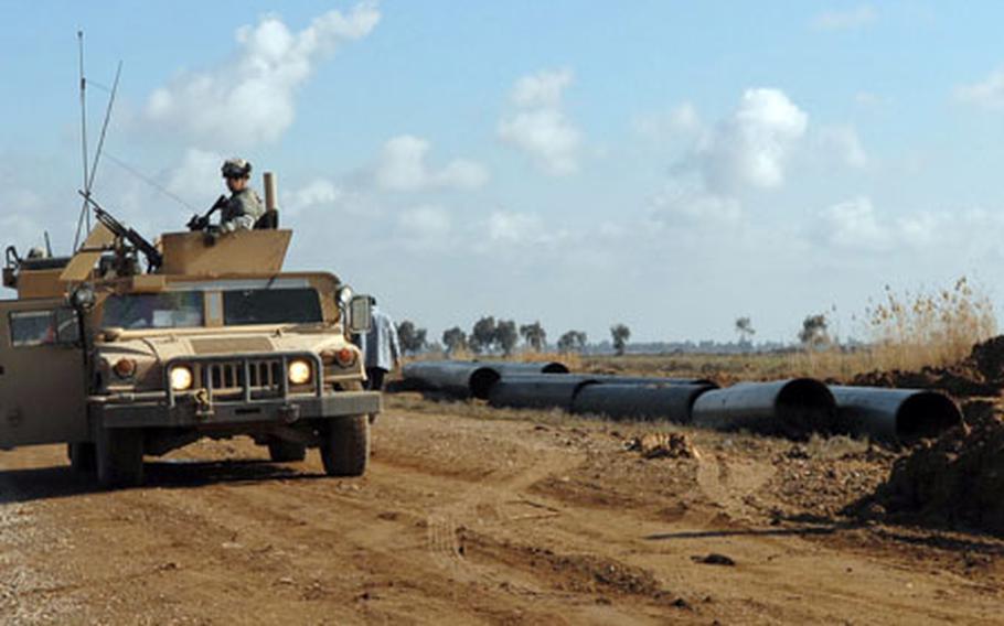 Members of the 3rd Battalion, 7th Field Artillery Regiment, 3rd Infantry Brigade Combat Team, 25th Infantry Division, stand watch Sunday as workers continue repairs to one of the several pipelines joining the oil fields near Kirkuk to the refinery in Beiji.