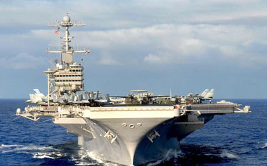 USS John C. Stennis steams in the Pacific Ocean during a photo exercise showcasing the entire John C. Stennis Carrier Strike Group off the coast of Guam. JCSSG entered the 5th Fleet area of operations Feb. 19 on a regularly scheduled deployment in support of Maritime Security Operations (MSO).