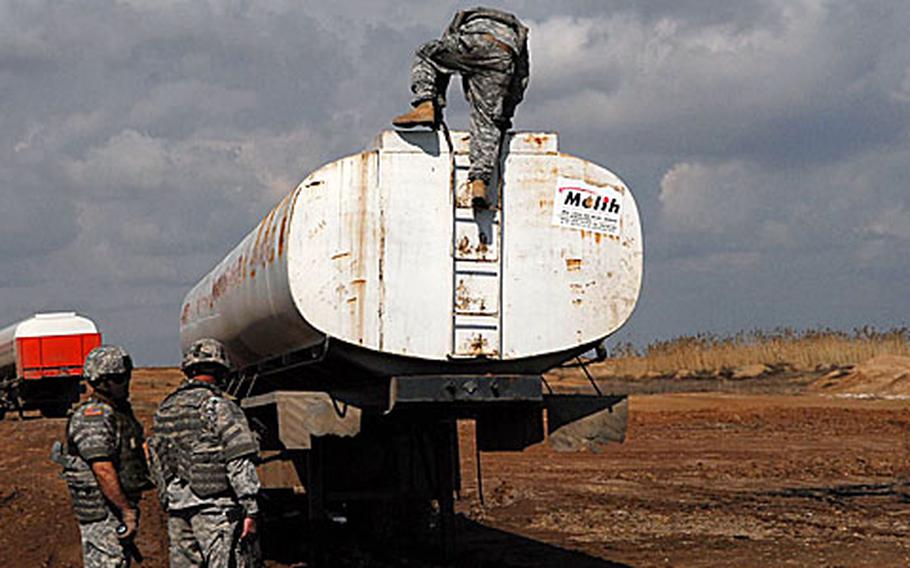 Members of the 3rd Battalion, 7th Field Artillery Regiment, 3rd Infantry Brigade Combat Team, 25th Infantry Division, on Sunday investigate several abandoned tankers left near oil pipelines linking Kirkuk, Iraq, and Beiji. (enw# 61p rb)