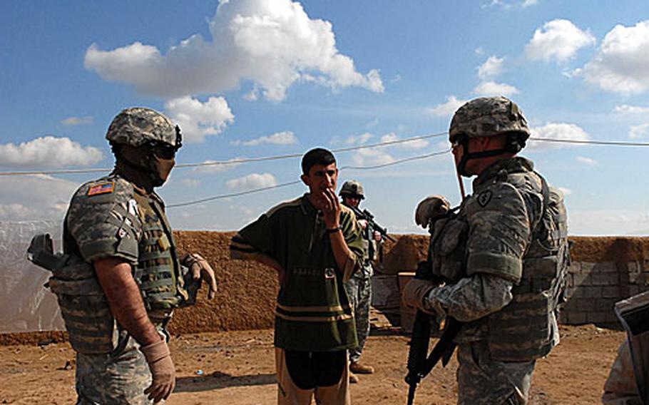 Members of the 3rd Battalion, 7th Field Artillery Regiment, 3rd Infantry Brigade Combat Team, 25th Infantry Division question a villager Sunday about possible oil smuggling about 30 miles southwest of Kirkuk.