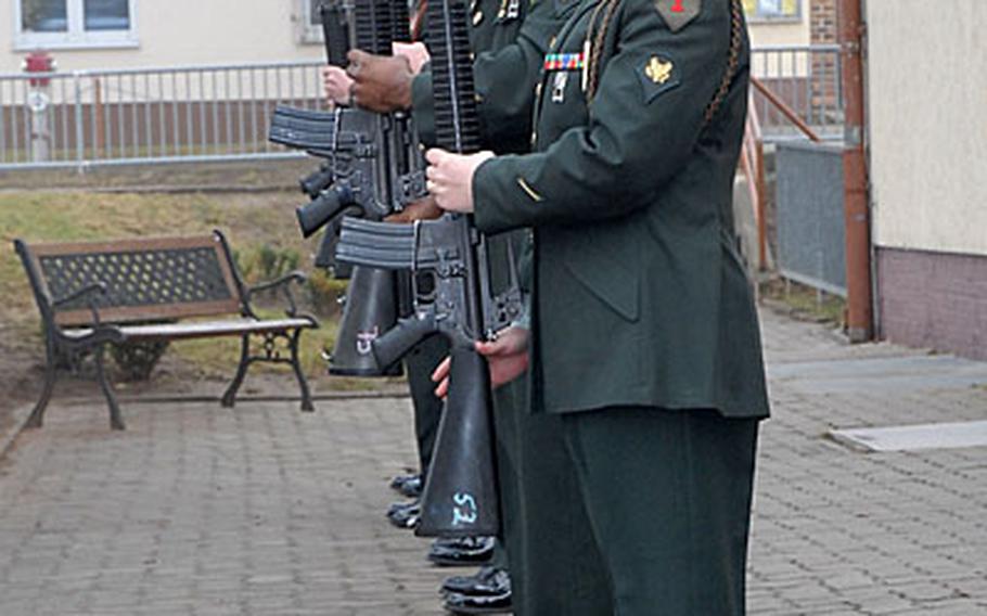 A squad of 1st Infantry Division soldiers presents arms for the playing of taps during a memorial ceremony Thursday for two fallen sergeants from 1st Battalion, 77th Armor Regiment, at the Ledward Barracks chapel in Schweinfurt, Germany.