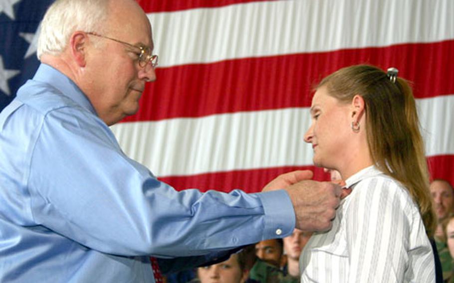 Vice President Dick Cheney pins the Exceptional Service Award on the collar of Tracy McVay, wife of Air Force Capt. Michael McVay, at Andersen Air Force Base, Guam, Thursday afternoon. She received the award for rescuing an airman who was swimming at Tarague Beach on Jan. 27.