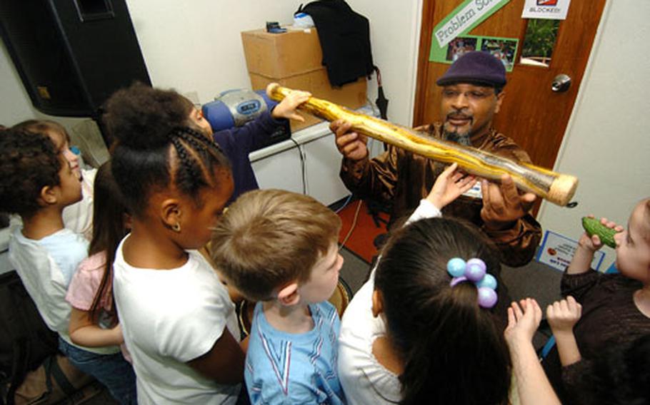James Childs teaches Tiffani Jones' first grade class about African drums at Yokota West Elementary School on Friday.