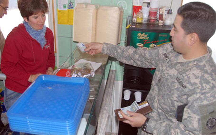 Staff Sgt. Carlos Gomez, 33, of Laredo, Texas, buys lunch from Armen, left, and Olga Oganesian at the Ararat kebab stand in Grafenwöhr on Wednesday. Armen Oganesian says Americans account for about one-half of his business.
