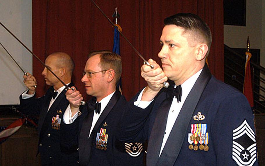 Chief Master Sgt. Gregory Blue, right, from the 100th Maintenance Group, practices a saber cordon ceremony with fellow chief master sergeants before RAF Mildenhall's annual awards ceremony on Feb. 23.