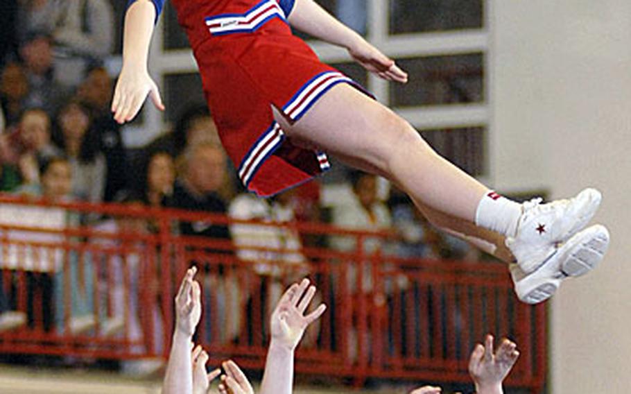 Amanda Turley, a freshman from Menwith Hill in the United Kingdom, soars into the arms of her cheerleading squad during their Division IV European Championship routine Saturday in Mannheim, Germany. Menwith Hill won their division.