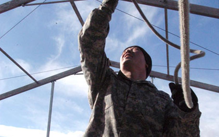 Sgt. Mike Tobin, of Headquarters and Headquarters Company, 1st Battalion, 37th Armor Regiment, 1st Brigade Combat Team, wrangles a rope Wednesday that will raise a sheath of canvas on a large fest tent at the site for the brigade's reception. Though funding for big welcome-home bashes has been slashed by the Army, the brigade, with help from other units and donated time by civilians and schoolchildren, has found ways around the funding shortage and will throw a party Tuesday that is almost as big as former blowouts at a fraction of the cost.