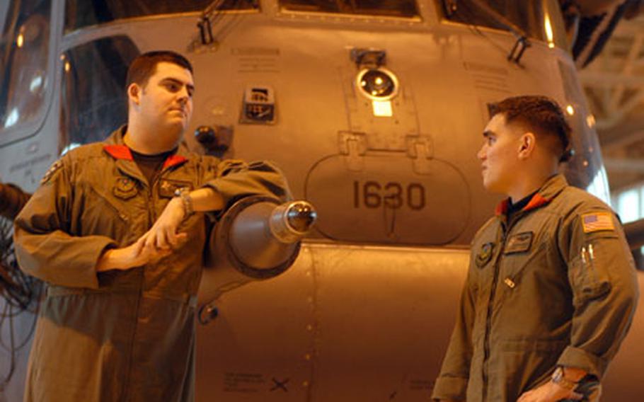 Capt. Charlie Mauze, 27, left, and Senior Airman Justin Shults, 24, chat about their future after the deactivation last this year of the MH-53J Pave Low helicopter in the background.